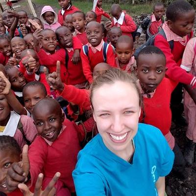 Empower Scholarship recipient from Chamberlain University taking a selfie with a group of children